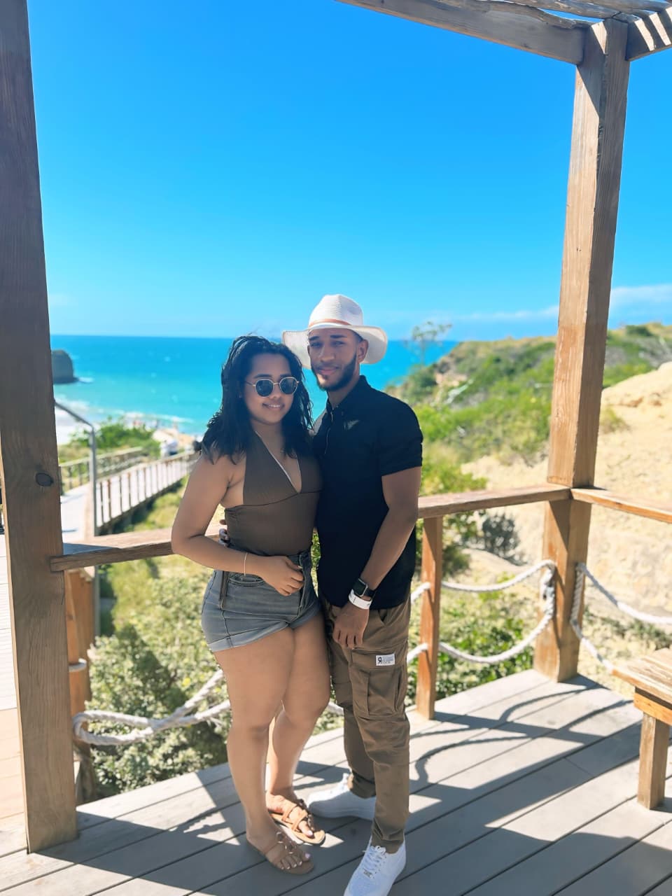 Michell y Anthony juntos frente a un paisaje costero